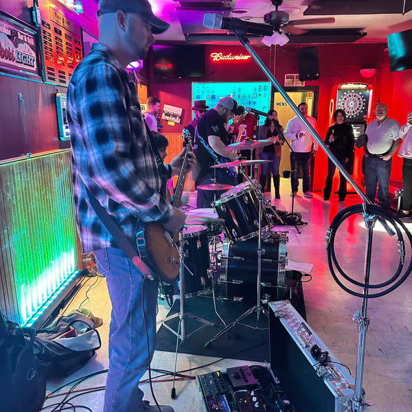 A band performs live music at The Horseshoe Bar & Grill, with patrons watching.